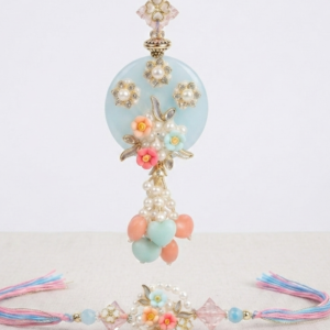 RichMade pastel floral Bhai Bhabhi Rakhi set featuring a handcrafted floral rakhi for brother and matching designer pearl lumba for sister-in-law.